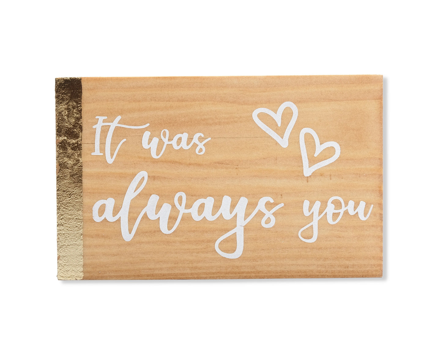 Small freestanding rectangular wooden sign facing straight on. Natural wood color, gold vertical border on left side only. White painted message, It was always you, with two heart outlines top right corner. Studio style photo on white background.
