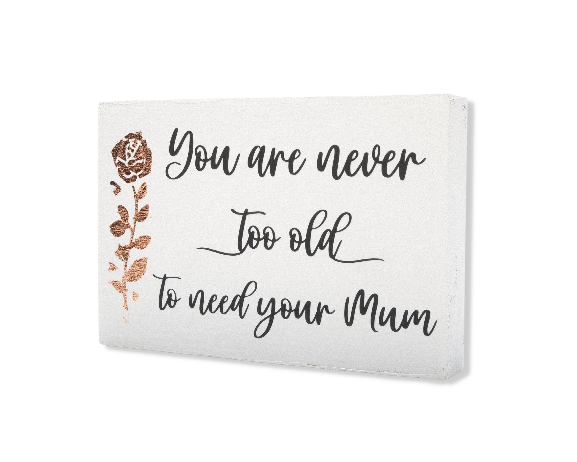 Small freestanding rectangular wooden sign displayed at 35 degree angle to show depth of sign. White wood stain, bronze rose gold tall rose flower on left side. Black message emotive font, You are never too old to need your Mum. Studio style photo.